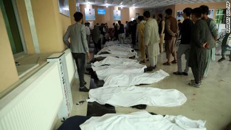 Afghan men try to identify the dead bodies at a hospital after a bomb explosion near a school west of Kabul, Afghanistan on Saturday.
