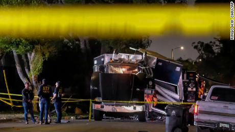 ATF investigators are seen next to the remains of an armored LAPD vehicle after fireworks exploded.