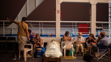 Elderly people are seen on chairs and makeshift bed onboard a ferry at the port of the village of Pefki, during a wildfire at Pefki village on Evia.
