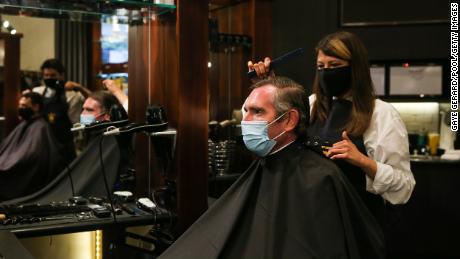 NSW Premier Dominic Perrottet receives a haircut on October 11, following the easing of Covid-19 restrictions in the state.