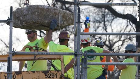 Workers guide a stone containing a time capsule that was placed in 1887.