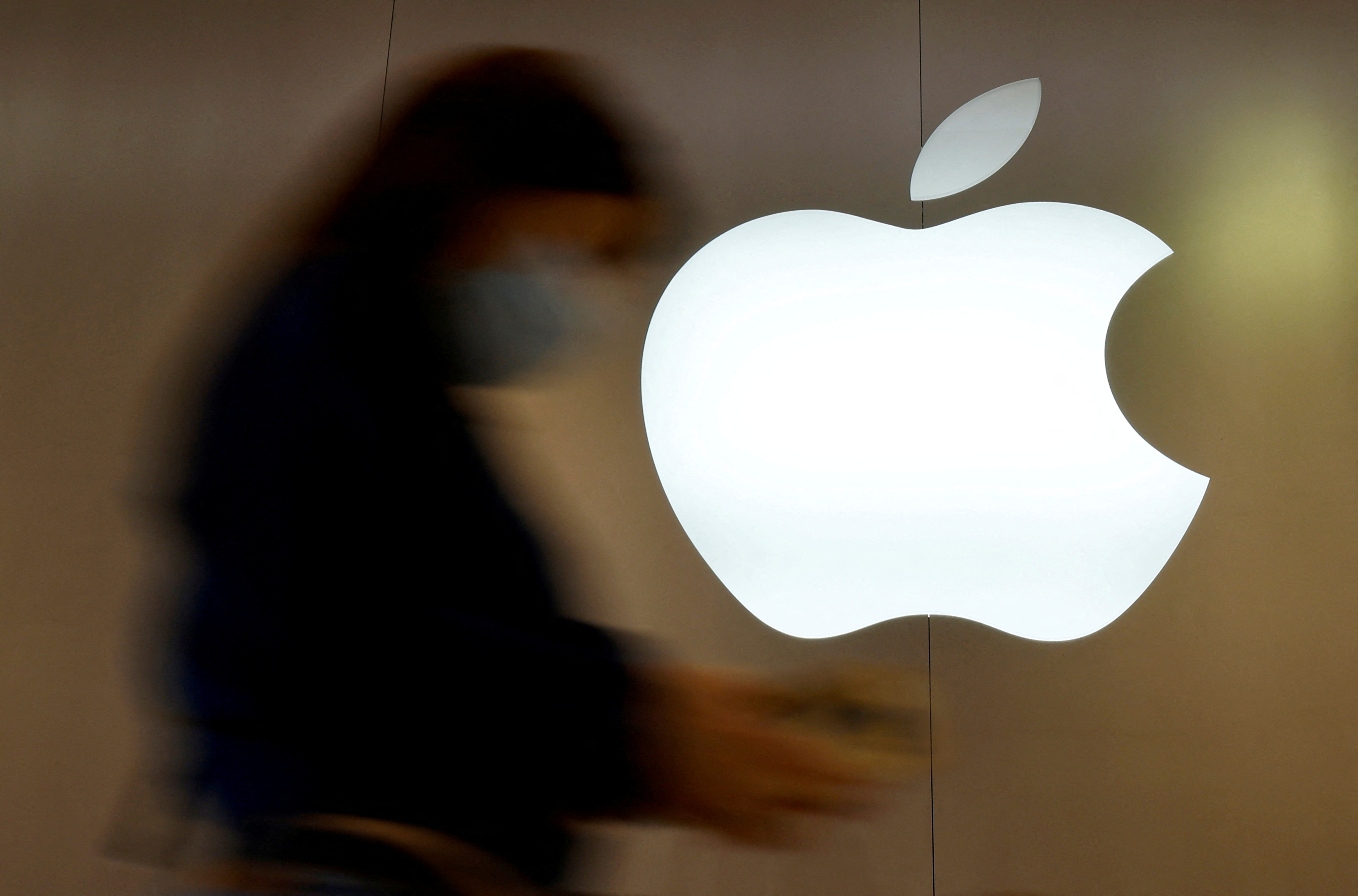 A woman walks past an Apple logo in front of an Apple store in Saint-Herblain near Nantes, France, September 16, 2021. REUTERS/Stephane Mahe