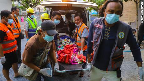 Members of a rescue team carry the body of Shel Ye Win, who was shot with a live round in the face during a crackdown by security forces on demonstrations against the military coup, in Mandalay on March 14, 2021.