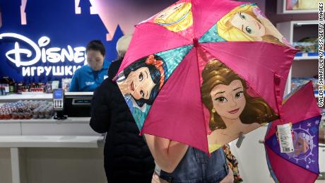 A shopper opening an umbrella featuring Disney Princesses at the Central Children's Store in Moscow's Lubyanka Square in 2017.