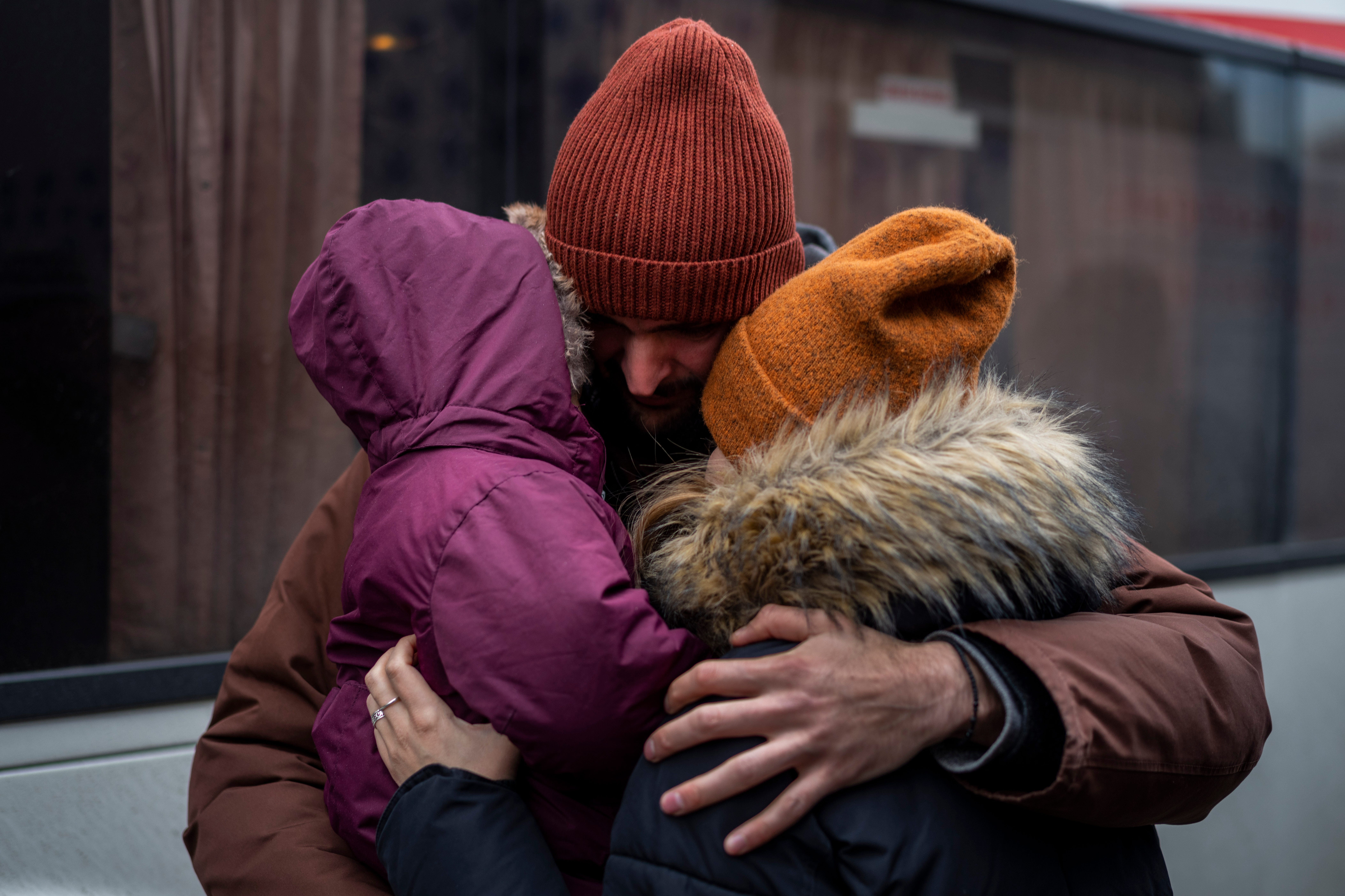 Ukrainian Pavlo Bilodid, 33, kisses his wife and daughter goodbye as they prepare to board a bus to Poland at Lviv bus main station, western Ukraine, Tuesday, March 1, 2022.