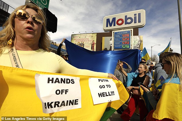 Hundreds of Ukrainian Americans and others protest near a gas station, featuring high prices for gas, during a rally to denounce Russia's invasion of Ukraine along Santa Monica Blvd in LA