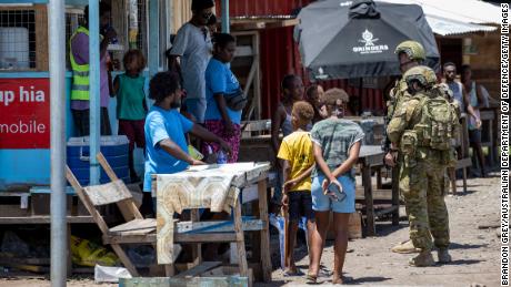 Australian Army soldiers talk with locals during a community engagement patrol through Honiara on November 27, 2021.