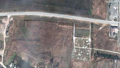 A satellite image from April 3 shows what appears to be a newly dug mass grave site, next to the cemetery.