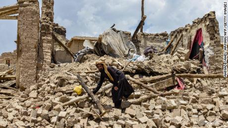 An Afghan man looks for his belongings amid the ruins of a house damaged by an earthquake.