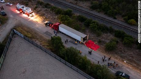 In this aerial view, members of law enforcement investigate a tractor trailer on June 27, 2022 in San Antonio, Texas. More than 50 people were found dead in an abandoned tractor trailer.
