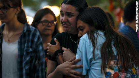Mourners embrace during a memorial for the victims of the July 4th parade shooting on July 5, 2022 in Highland Park, Ill.