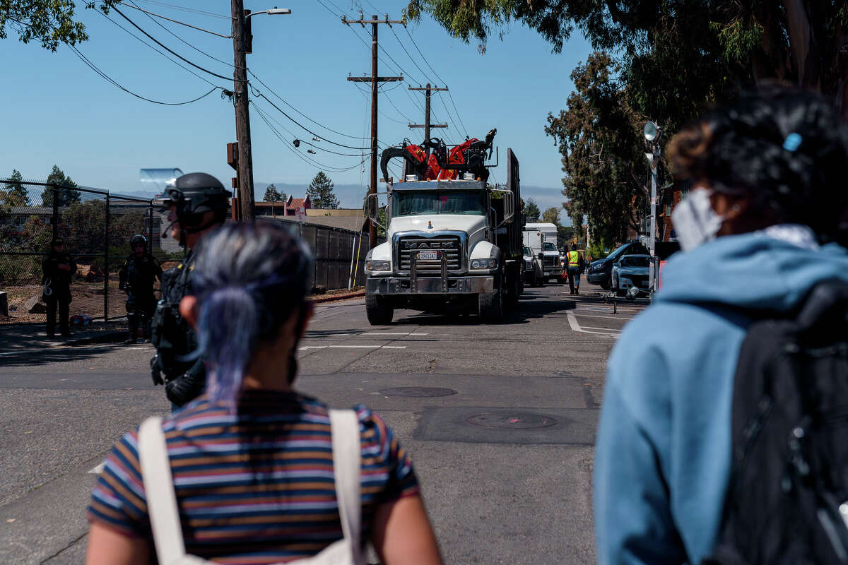 People block contractors and their equipment used for cutting down trees from leaving People's Park in Berkeley, Calif., on Wednesday, Aug. 3, 2022.