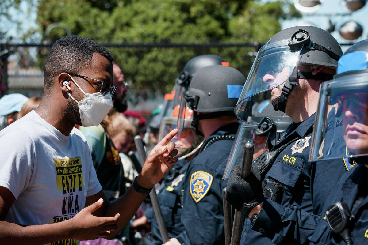 A person shakes his finger at a California Highway Patrol officer during a protest at People's Park in Berkeley, Calif., on Wednesday, Aug. 3, 2022.