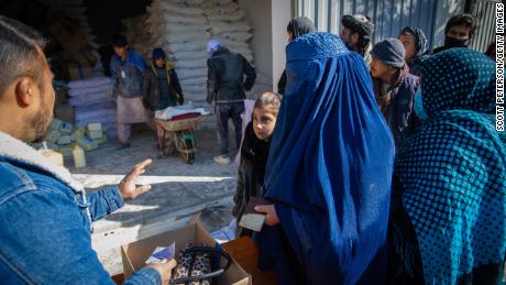 An Afghan woman collects her family's monthly ration of staple foods from a World Food Programme distribution point in the Jaie Rais district of western Kabul.