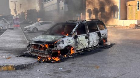 A car burns in the street during clashes in Tripoli, Libya August 27, 2022.