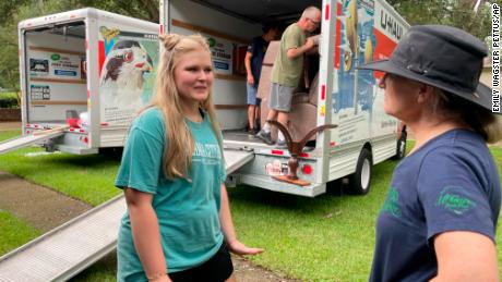 Medical student Emily Davis, left, speaks with her landlord Suzannah Thames Friday as workers move furniture, appliances and other belongings out of a home Davis and her husband are renting in a flood-prone area of Jackson, Mississippi.