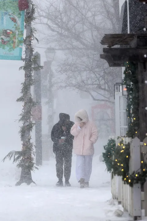 People walk in the blizzard on Main Street in Unionville, which is decorated for Christmas.