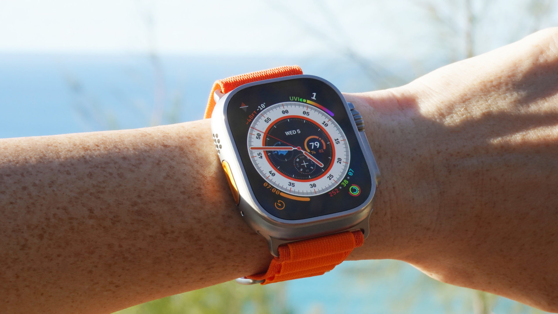 Apple Watch Ultra Wayfinder An Apple Watch Ultra on a user's wrist displays the Wayfinder watch face.