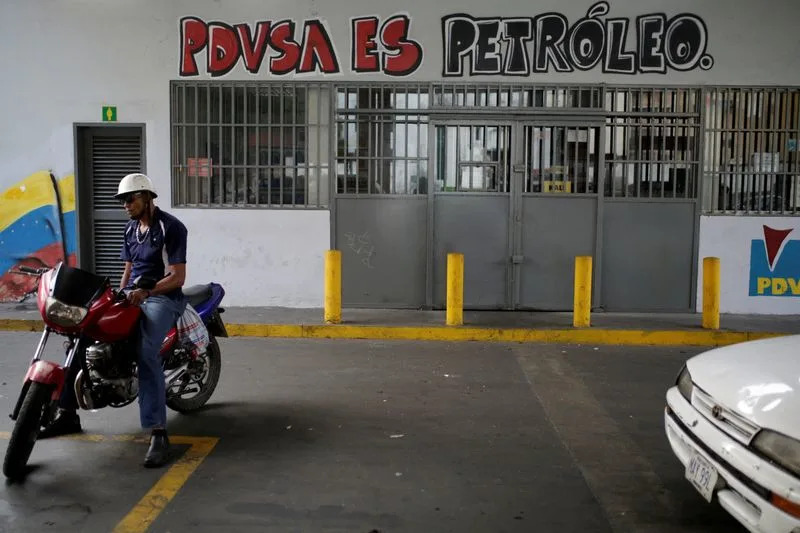 FILE PHOTO: FILE PHOTO: A graffiti that reads "PDVSA is oil" is seen at a gas station in Caracas
