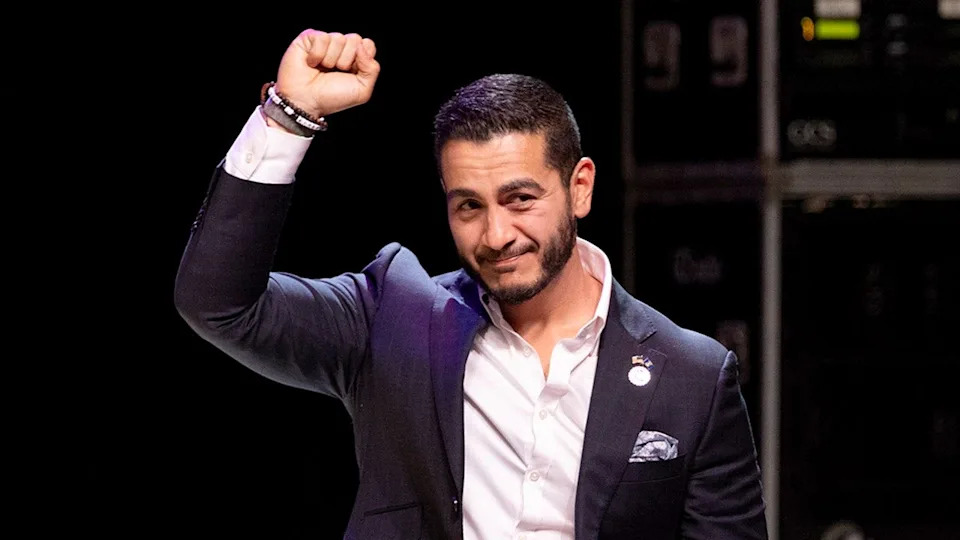 Abdul El-Sayed is seen raising his hand to a crowd of supporters.