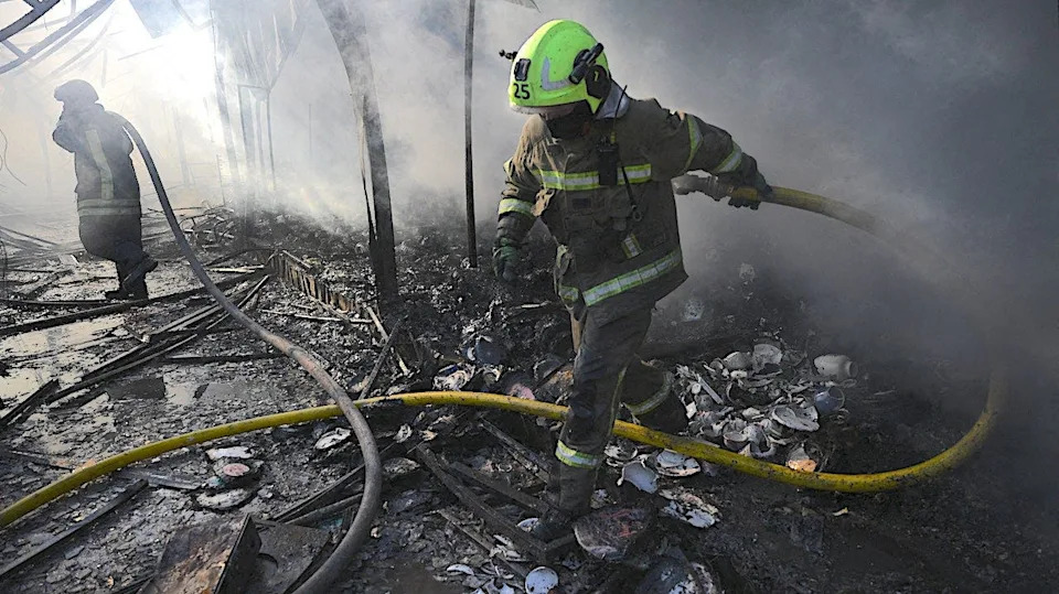 Ukrainian firefighters extinguish a fire at a market in Kyiv following a Russian missile strike.