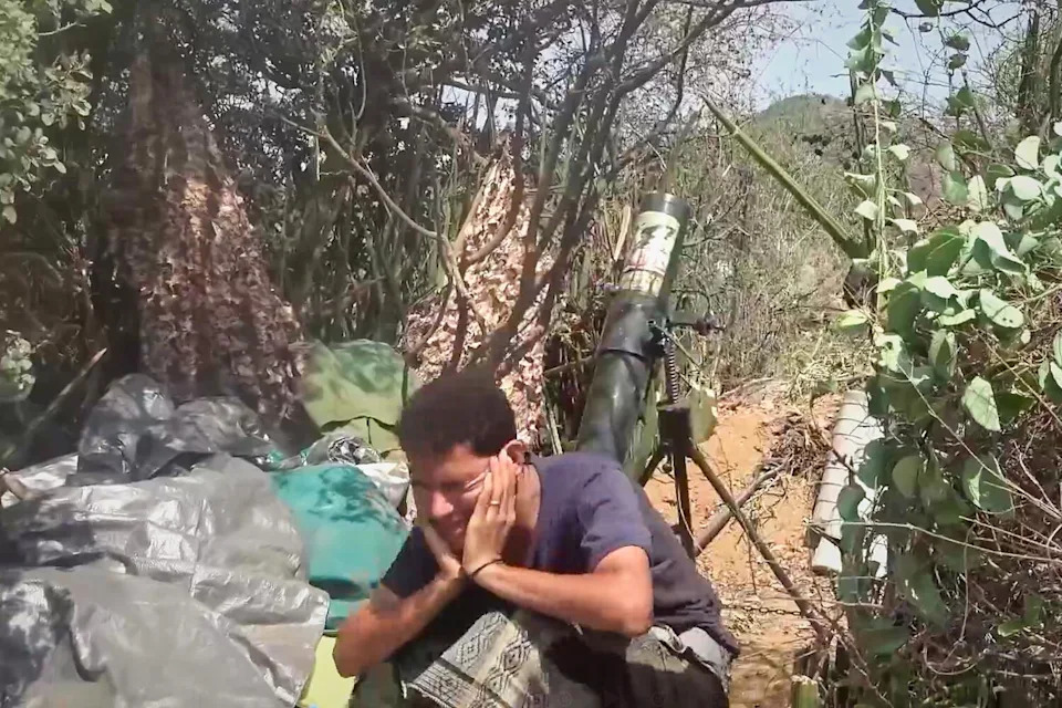 a Houthi fighter firing a mortar during clashes