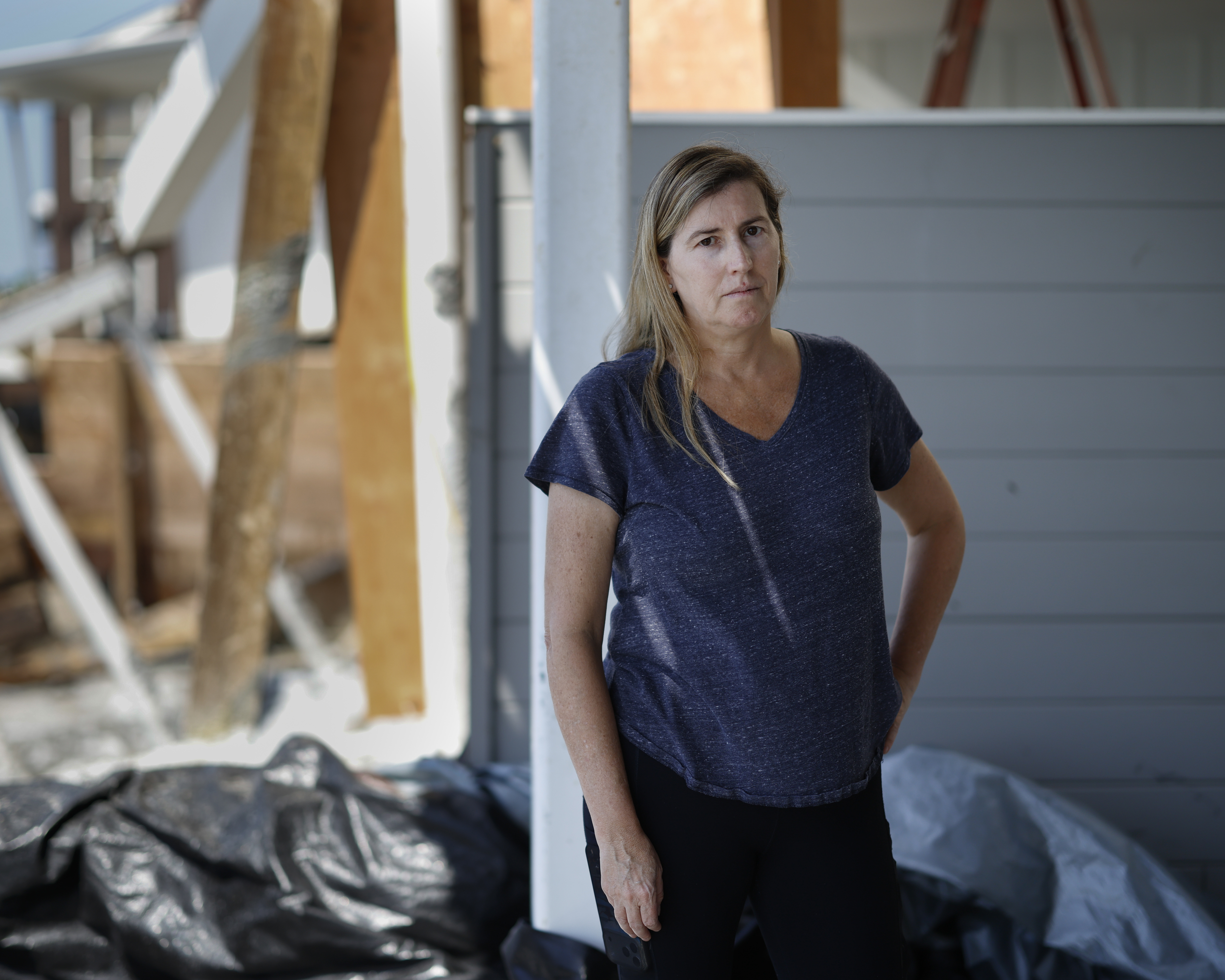 Natalie Driessen in front of her Dana Point home. It is still standing, but her backyard was wrecked. - (Caroline Brehman/For The Washington Post)