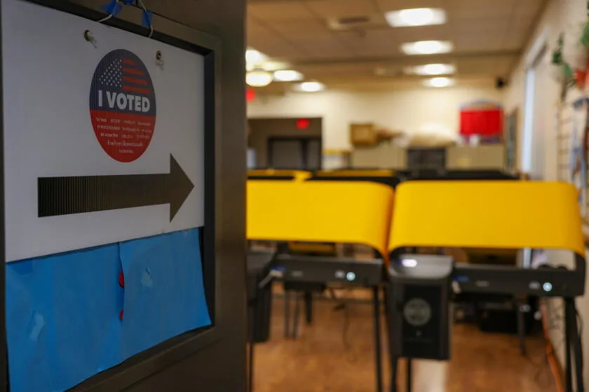 A sign points toward voting stations inside the Arroyo Seco Regional Branch Library in Los Angeles.