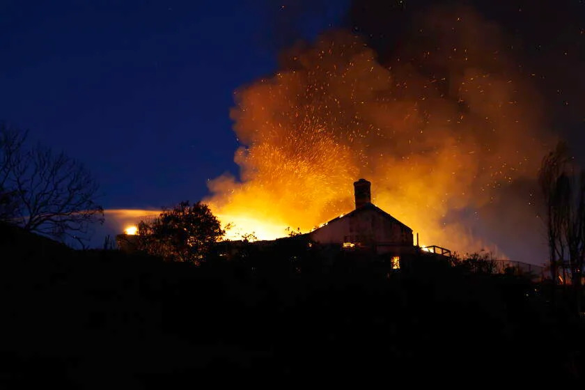 Burning embers swirl in balls of fire that engulfed a home above Calle Miramar during the Norte fire.